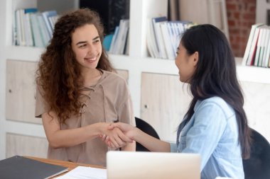 İki çekici kız masada kapalı otururken el sıkışıyor