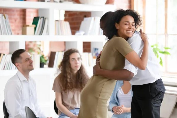 Vrouw psycholoog verslaving raadsman knuffelen ondersteunende kerel tijdens de groepssessie — Stockfoto