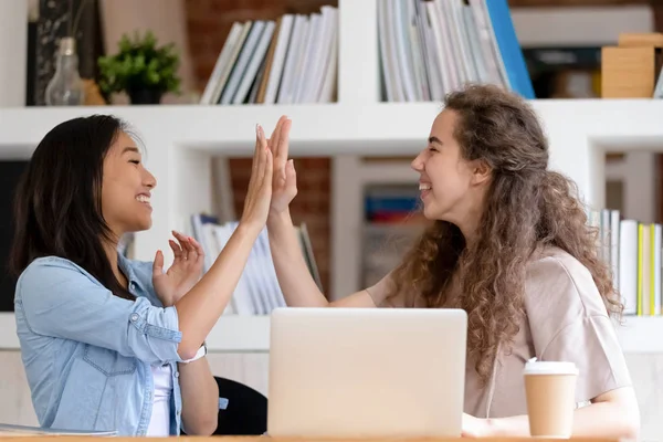 Cheerful student girls feels happy celebrating success giving high five — Stock Photo, Image