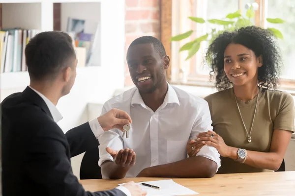 Realtor geven sleutels aan nieuw huis aan Afrikaans getrouwd stel — Stockfoto