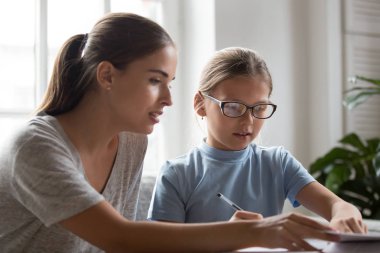 Anne küçük kızı için okul görev ödevi ile yardımcı olur