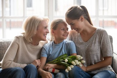 Küçük kız anne ve büyükanne çiçek ve hediye aldı