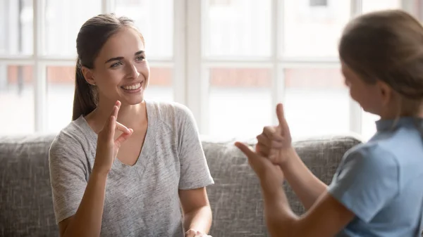 Young mother talking with deaf daughter using visual-manual language — Stock Photo, Image