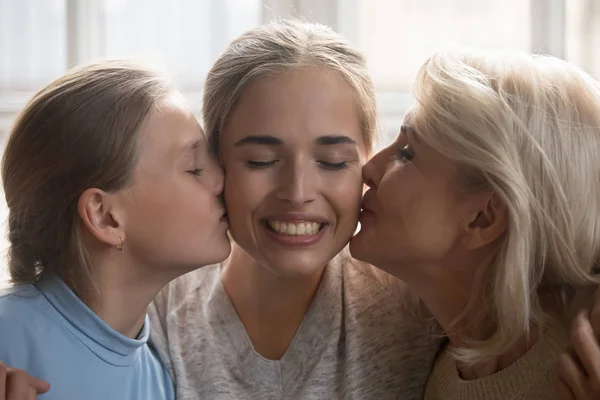 Closeup faces woman her daughter and elderly mother kiss her — Stock Photo, Image