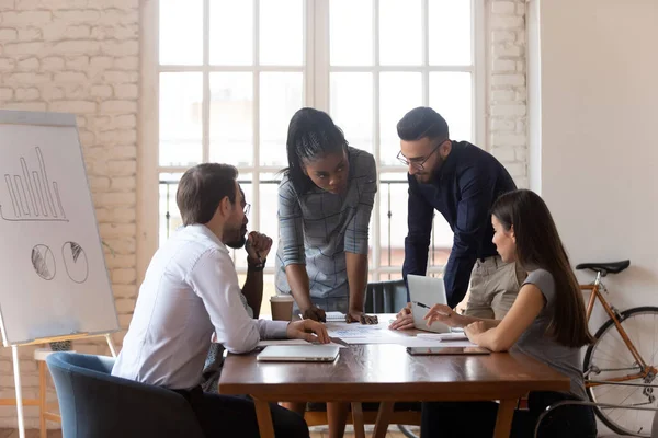 Equipo de negocios multirraciales que coopera discutiendo el papeleo en la mesa de oficina — Foto de Stock