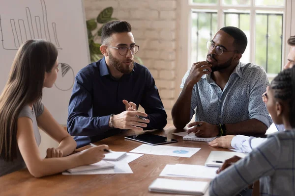 Charla ejecutiva seria del hombre de negocios con el personal diverso en mesa informativa —  Fotos de Stock