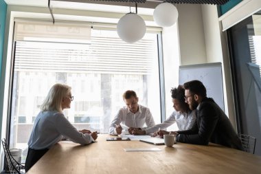 Olgun takım lideri yönetim kurulu odasında çeşitli çalışanlarla brifing veren