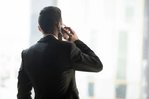 Rear view confident businessman talking on phone with business partner — Stock Photo, Image