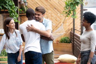 Mutlu çeşitli erkek arkadaşlar dostluk toplantısında toplantı kucaklamak