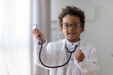 Sevimli afrikalı çocuk çocuk doktor, portre oynarken tıbbi üniforma giymek