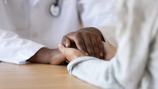 Mujer agradecida paciente cogida de la mano de un médico negro africano —  Fotos de Stock