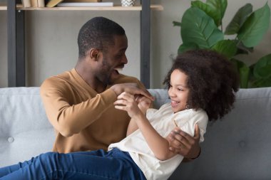 Evde okul öncesi kızı ile oynayan Mutlu Afrikalı Amerikalı baba