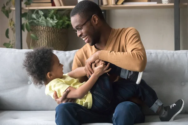 Feliz pai afro-americano brincando com o filho da criança em casa — Fotografia de Stock