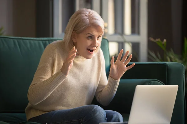 Дивовижна збуджена стара жінка середнього віку переможець дивиться на ноутбук — стокове фото