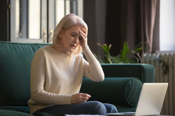 Fatigué bouleversé femme mature se sentir mal de tête après le travail informatique — Photo