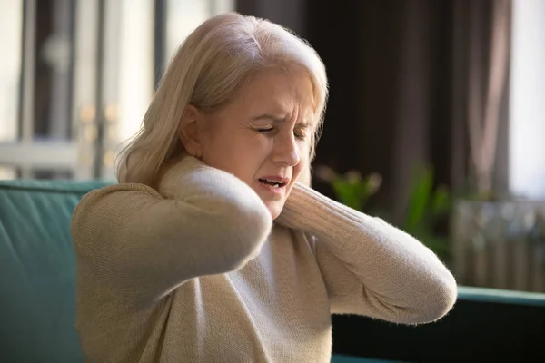 Tired upset old senior woman feeling stiff neck pain concept — Stock Image Tired upset old senior woman feeling stiff neck pain concept Stock Photo