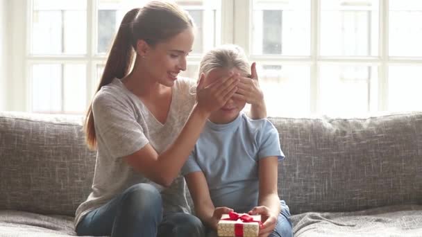 Madre cubrir los ojos con la mano hija y presentar su regalo — Vídeo de stock