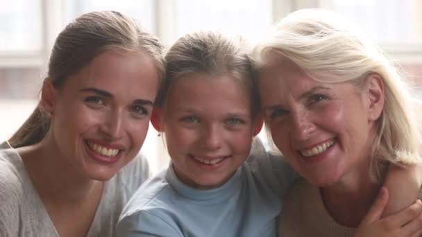 Портрет крупным планом трех поколений женщин, обнимающих и смеющихся в помещении — стоковое видео