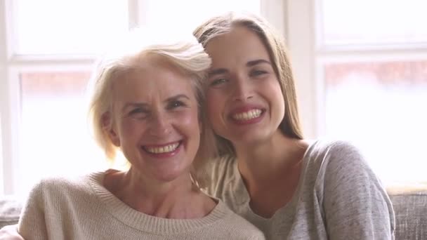 Retrato de la cabeza riendo hija adulta abrazando a la madre de mediana edad — Vídeos de Stock