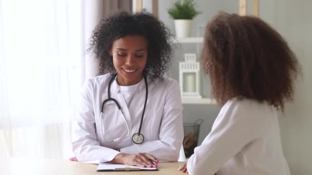 Africano médico y adolescente chica teniendo confidencial conversación — Vídeo de stock