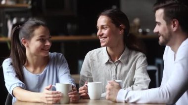 Çeşitli arkadaşlar kafede vakit geçirmekten bahseden çay içiyor