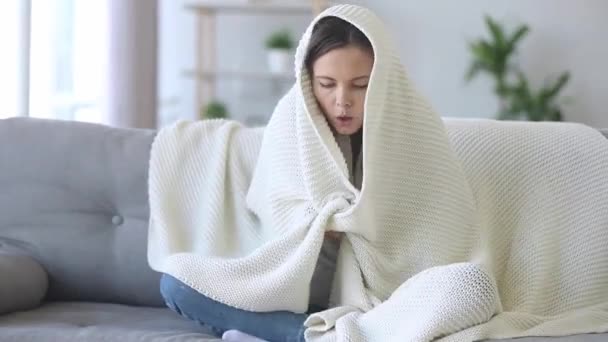 Woman covered with white plaid feels frozen at home — Stock Video