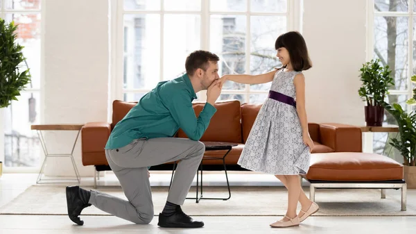 Dad standing on knee kissing hand of daughter after dance — Stock Photo, Image