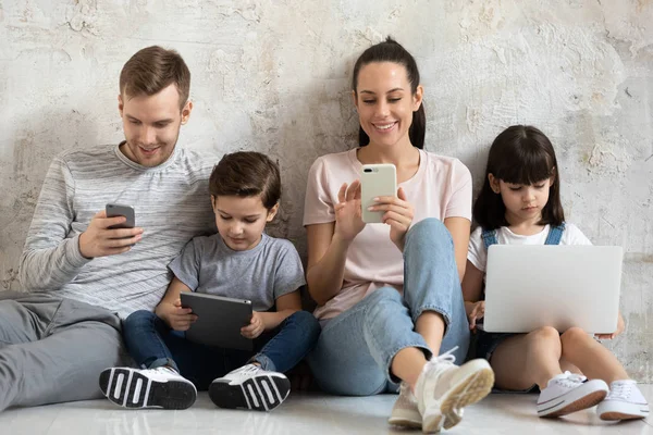 幸せな技術中毒の親と子供は自宅でデバイスを使用します — ストック写真