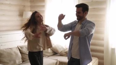 Aktif neşeli bin yıllık çift oturma odasında dans kalma keyfini çıkarın