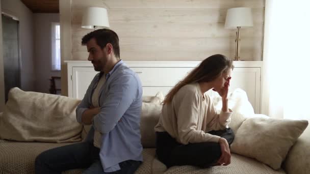 Unhappy couple ignoring each other sitting apart on couch — Stock Video