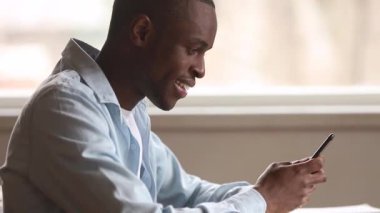 Yakın yana görüş afrikalı adam akıllı telefonda oyun oynamak