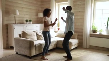 Oturma odasında dans eden koyu tenli çift hayatın tadını çıkarıyor