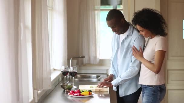 Africano cara preparar romântico jantar menina amada abraça-lo atrás — Vídeo de Stock