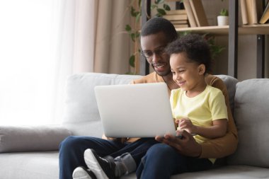 Afro-Amerikan baba dizüstü bilgisayar kullanmak için küçük oğlu öğretim