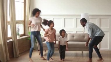 Çocuklu Afrikalı aile evde dans ederken aktif zaman geçiriyor