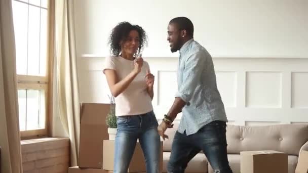 Zwart paar vieren verhuizen op nieuwe thuis dansen voelt gelukkig — Stockvideo