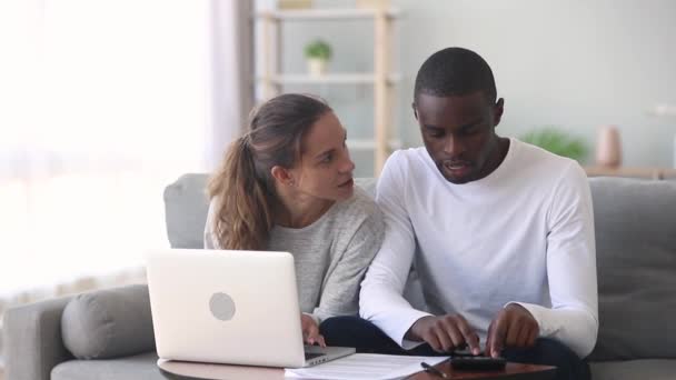 Различные супруги управляют семейным бюджетом обсудить кредитный договор с помощью компьютера — стоковое видео