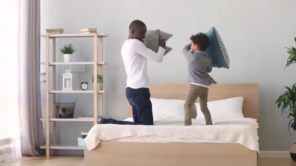 Africano padre jugando almohada lucha con poco hijo — Vídeo de stock