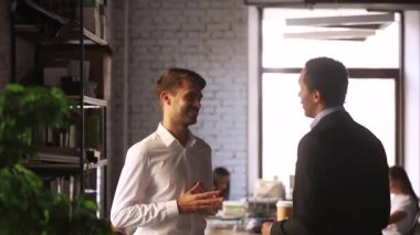 Farklı etnik işadamları iş günü işbirliği ofisinde konuşuyor