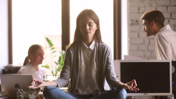 Mentre i colleghi discutono donna seduta alla scrivania focalizzata sulla meditazione — Video Stock