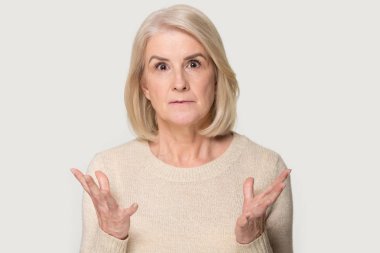 Gri arka planda izole şaşırmış yaşlı kadın anlaşma ile şok