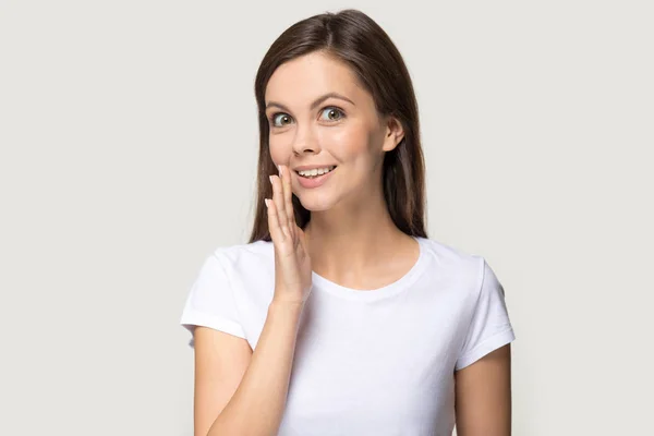 Smiling millennial girl look at camera tell secret information — Stock Photo, Image