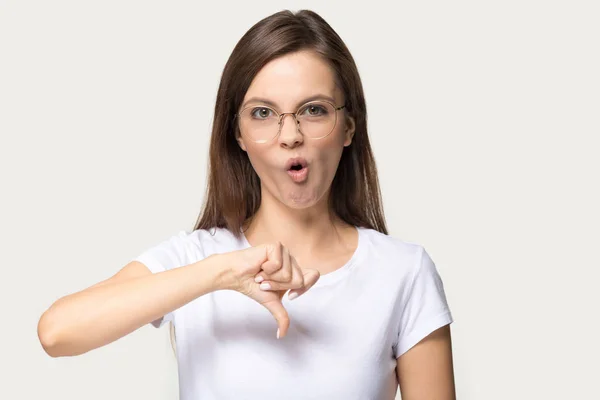 Разочарованная девушка в очках показывает большой палец вниз жест — стоковое фото
