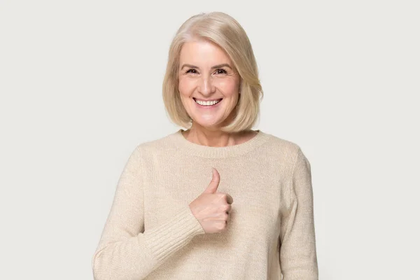 Šťastná dospělá žena ukazuje palce doporučující službu — Stock fotografie