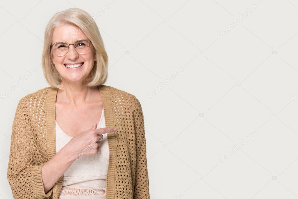 Smiling mature woman isolated point at blank copy space