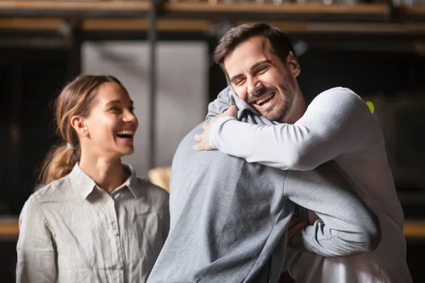 Felices amigos masculinos diversos abrazando el saludo de risa en la cafetería —  Fotos de Stock