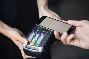 Erkek müşteri nfc terminali, closeup üzerinde telefon tutan ödeme yapmak