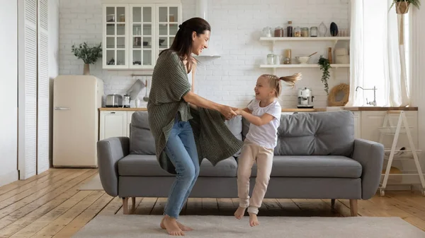 Mãe dançando de mãos dadas com a filha pré-escolar em casa — Fotografia de Stock