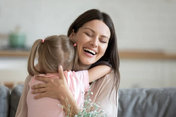 Mãe sincera alegre abraçar filha expressar gratidão por flores — Fotografia de Stock