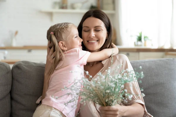Дочь обнимает мать сделать приятный сюрприз для нее подарил цветы — стоковое фото